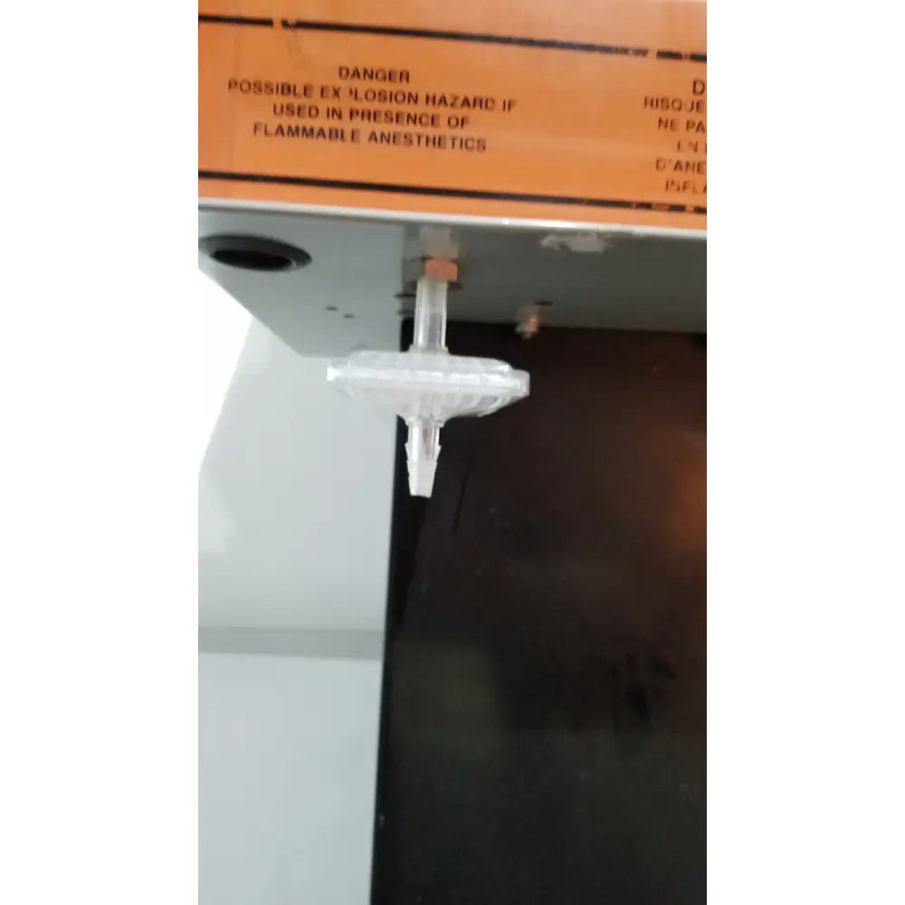 Clear plastic gas filter with cylindrical body mounted on orange label for allied healthcare gomco 3040 aspirator