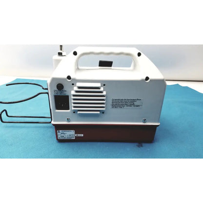 White and brown portable air compressor with handle and black power cord showing ventilation slats at back for allied healthcare gomco optivac g180