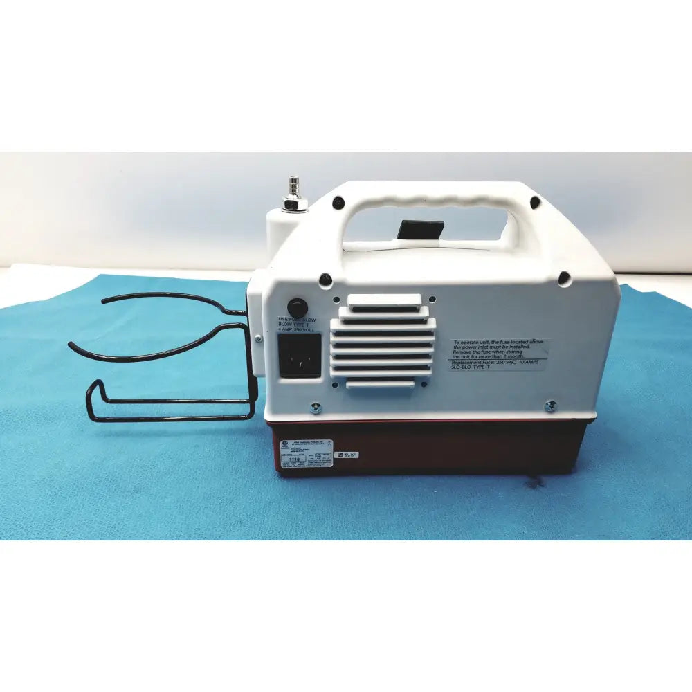 White and brown allied healthcare gomco optivac g180 portable aspirator showing handle power input and metal wire rack