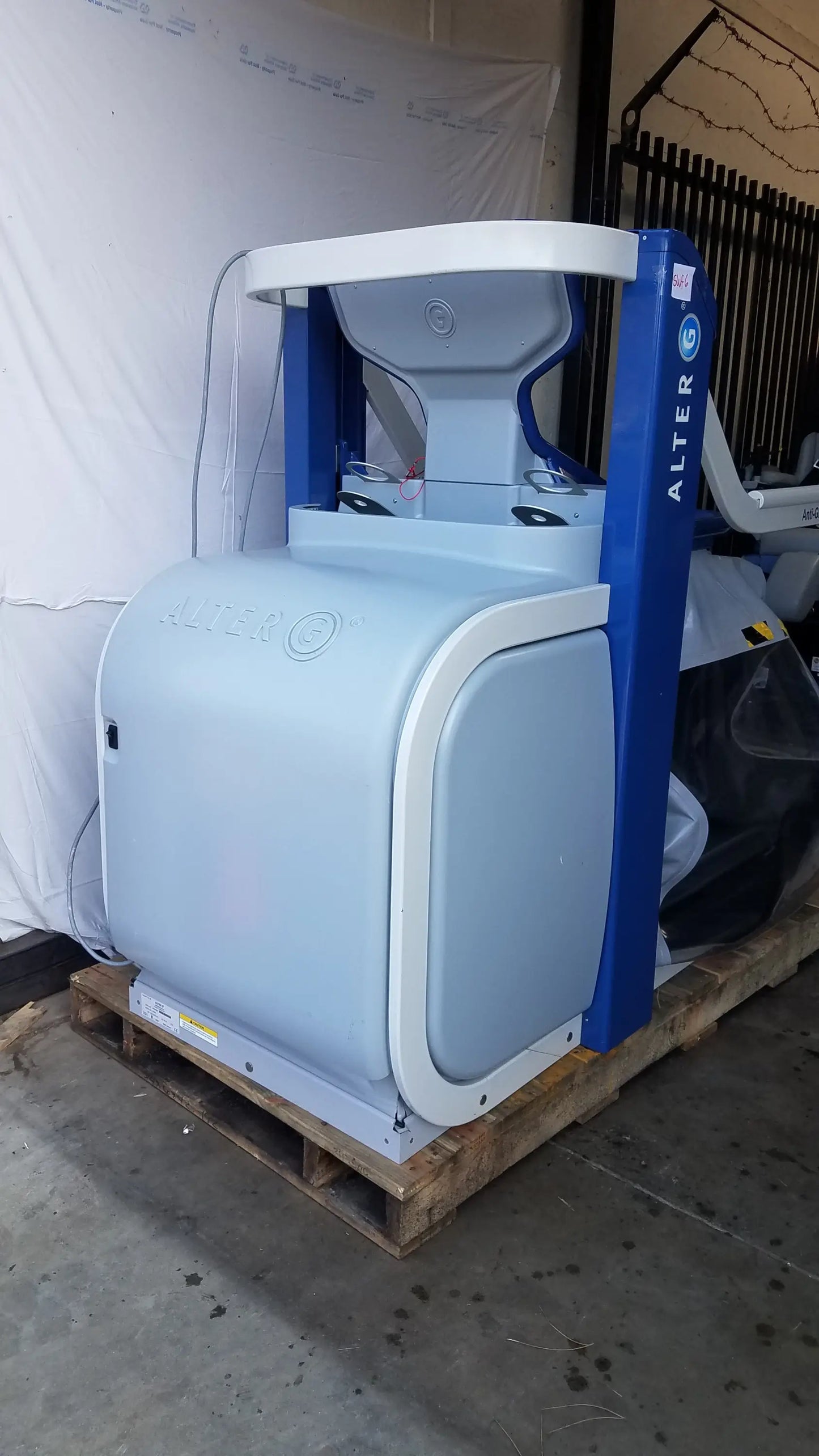 Blue and light gray alter brand arcade-style anti-gravity treadmill with curved white trim and adjustable body-weight support