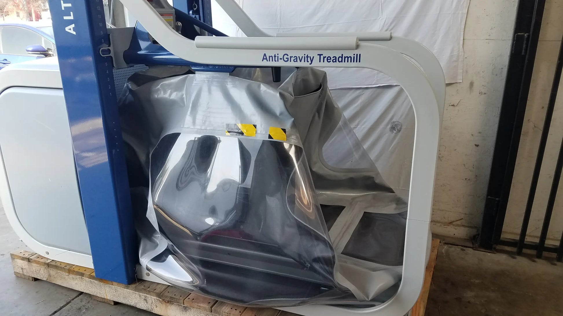 Alter G M320 anti-gravity treadmill with adjustable body-weight support featuring white and blue design and metallic running surface