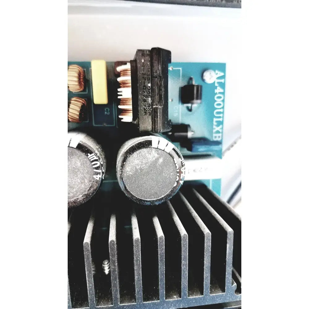Black cylindrical capacitors with silver tops on a black heat sink in the altronix al400ulx power supply charger