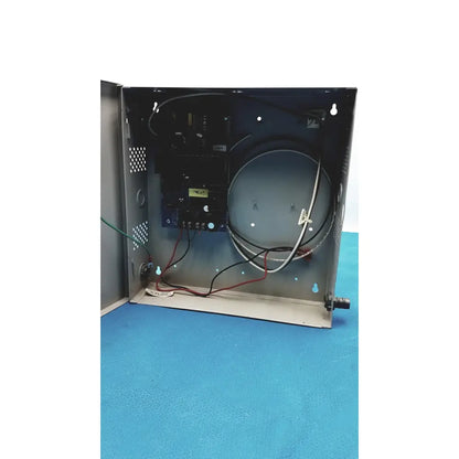 Gray metal enclosure of altronix al400ulx power supply housing electronic components and coiled wires for 12vdc or 24vdc use