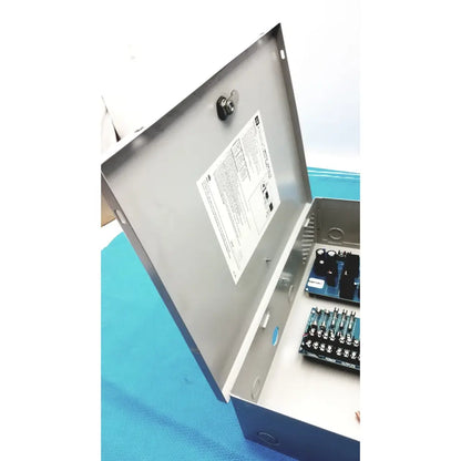 Gray metal altronix smp5ctx high current power supply with hinged door lock and internal circuit boards for 12vdc/24vdc use