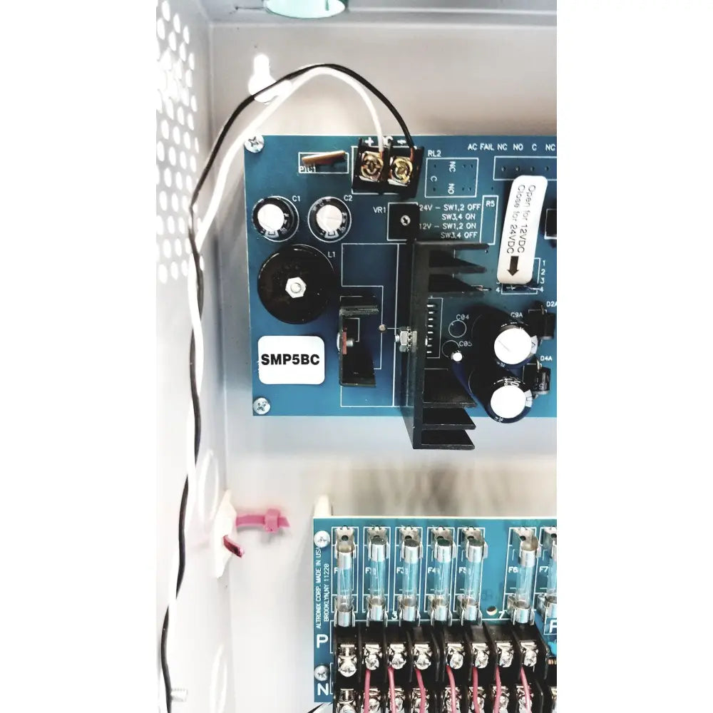 Blue smp5bc circuit board with white knobs and labeled components in altronix smp5ctx high current power supply charger