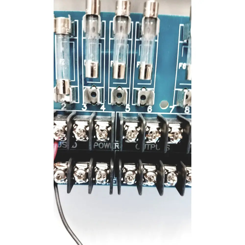 Blue circuit board of altronix smp5ctx high current power supply with clear glass fuse holders and silver metal terminals