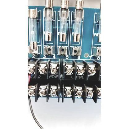 Blue circuit board of altronix smp5ctx high current power supply with clear glass fuse holders and silver metal terminals