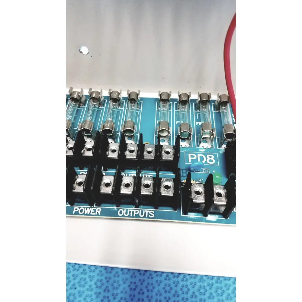 Blue pd8 power distribution board with black terminal blocks and glass fuses for altronix smp5ctx high current supply