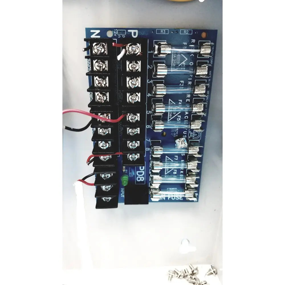 Blue circuit board with black terminal blocks and clear glass fuses in altronix smp5ctx high current power supply