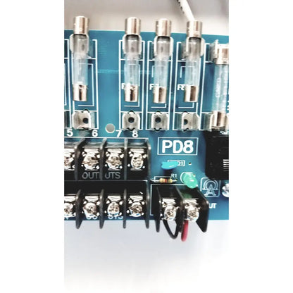 Blue circuit board with transparent glass fuses and black terminal blocks in altronix smp5ctx high current power supply