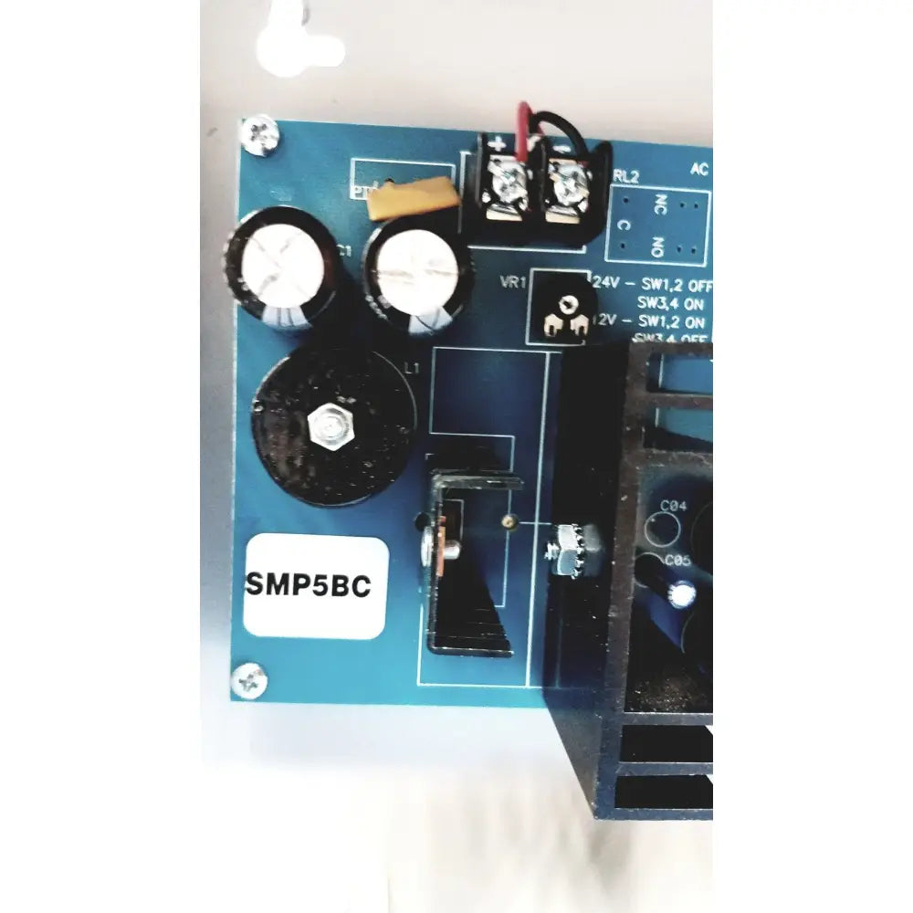 Blue printed circuit board with black capacitors and screws of altronix smp5ctx high current power supply charger