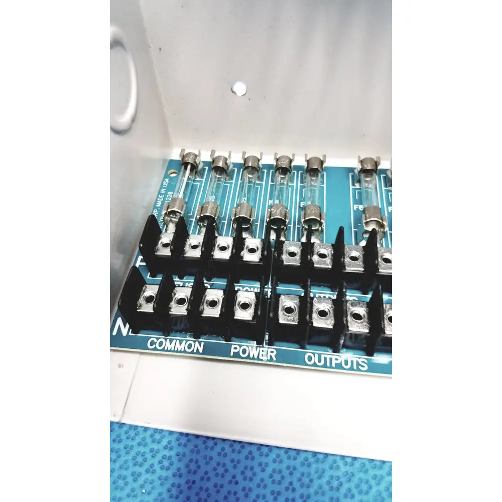 Blue circuit board with black terminal blocks and glass fuses in altronix smp5ctx high current power supply charger