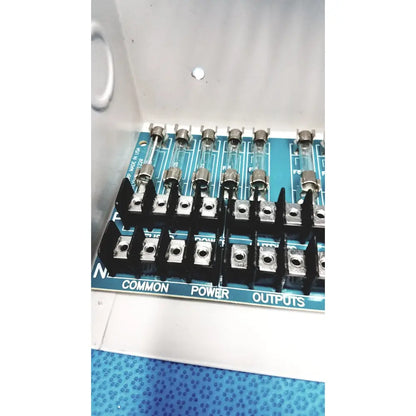 Blue circuit board with black terminal blocks and glass fuses in altronix smp5ctx high current power supply charger