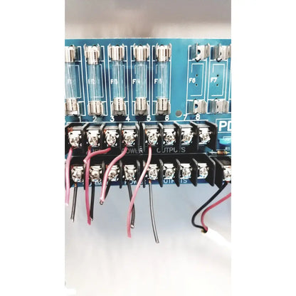 Blue circuit board of altronix smp5ctx power supply with glass fuses f1-f8 and black terminal blocks for power outputs