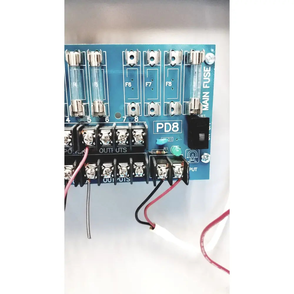 Blue pd8 main fuse panel with clear glass fuses and silver terminal blocks on altronix smp5ctx power supply charger