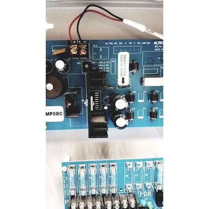 Blue circuit board of altronix smp5ctx power supply with black and white components for 12VDC or 24VDC charging