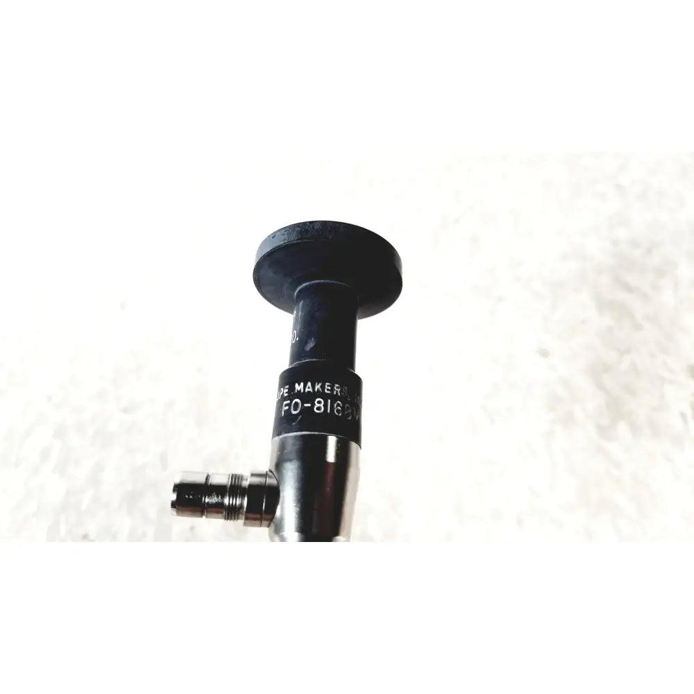 Black cylindrical medical device with metallic threaded connector labeled de maker fo-8169 by american cystoscope makers