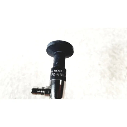 Black cylindrical medical device with metallic threaded connector labeled de maker fo-8169 by american cystoscope makers