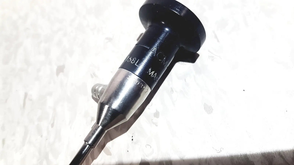Black and silver medical endoscope with textured grip and engraved markings by american cystoscope makers inc