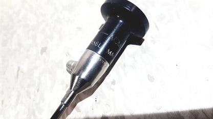 Black and silver medical endoscope with textured grip and engraved markings by american cystoscope makers inc