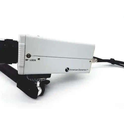 White rectangular american dynamics adcshr2412n bf lock camera mount with black hardware and attached cable back view