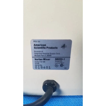 Gray rectangular label on a white american scientific sp vortex mixer model s8223-1 identifying the product details
