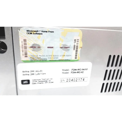White plastic label with black text and barcode on the back of american telecare lifeview home video patient monitor