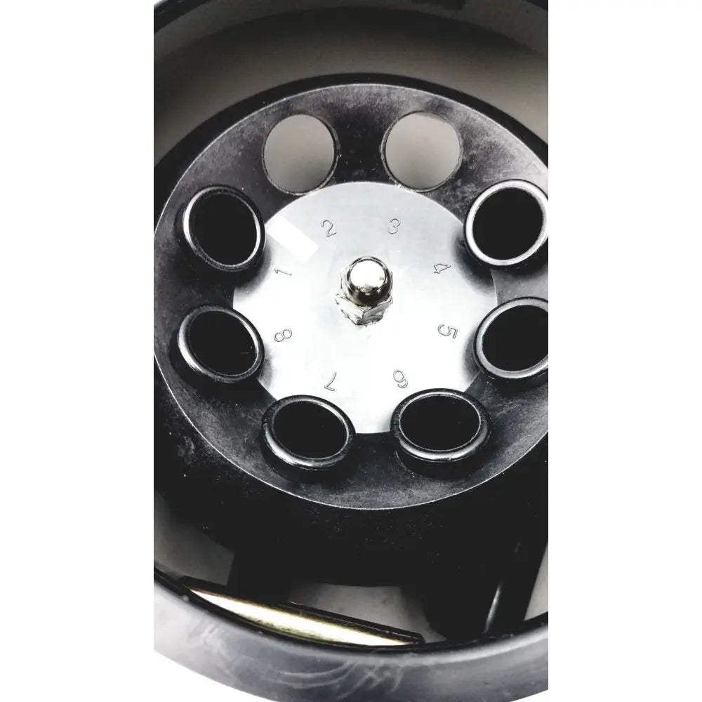 Black rotary phone dial with silver center plate and numbered slots on ample scientific champion E33 centrifuge timer panel