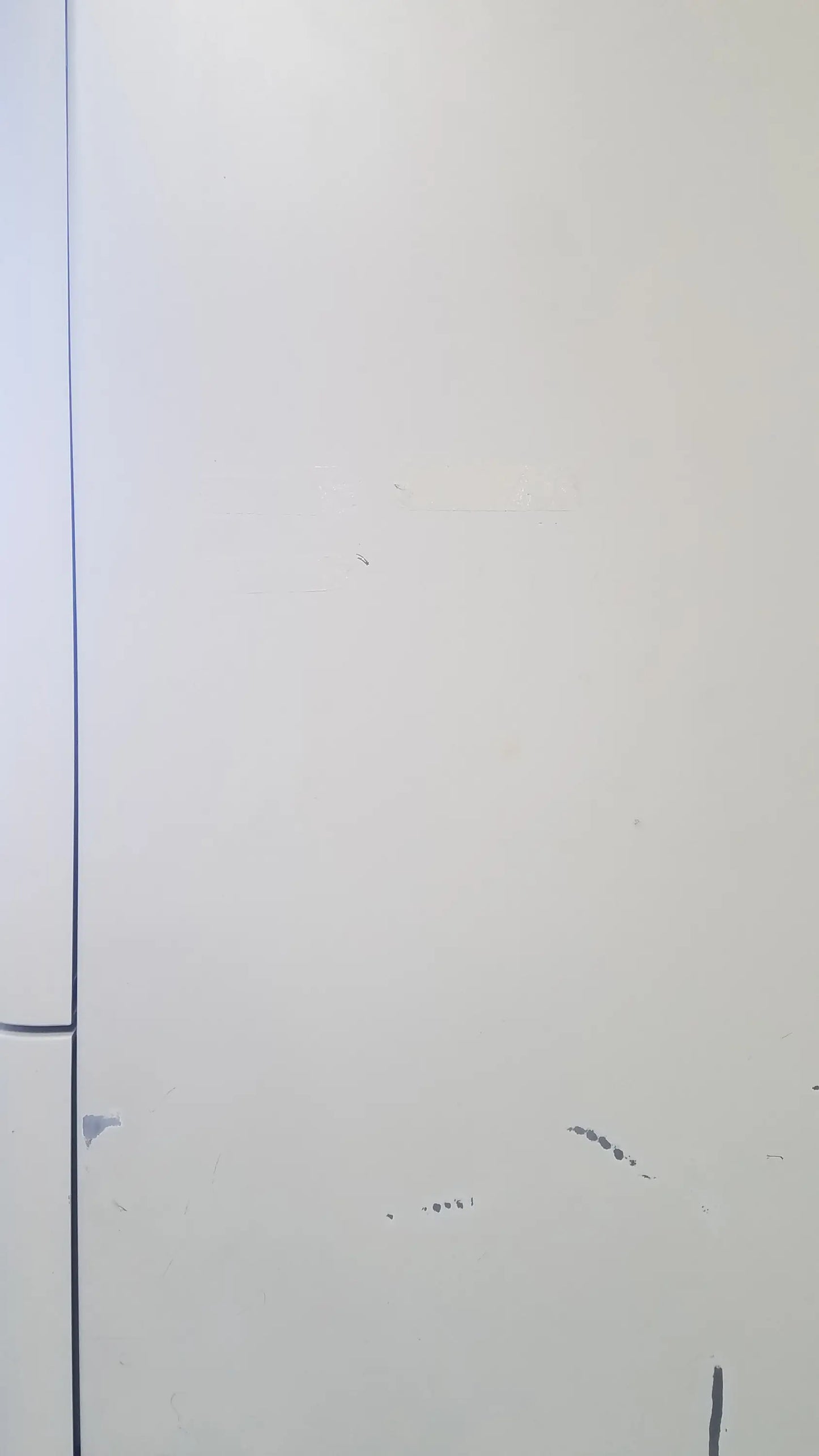 A plain white door with a vertical seam and minor scuff marks on the amsco steris v-pro max low temperature sterilization system