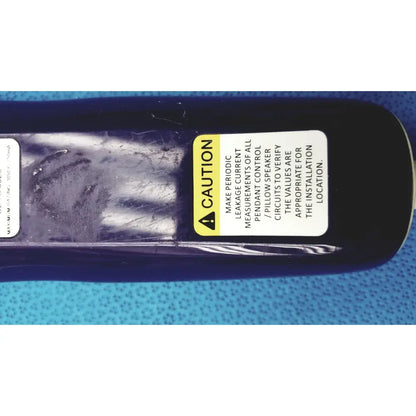 Black cylindrical anacom medtek b0857-088dj pillow speaker remote with yellow and white caution label for hill-rom use
