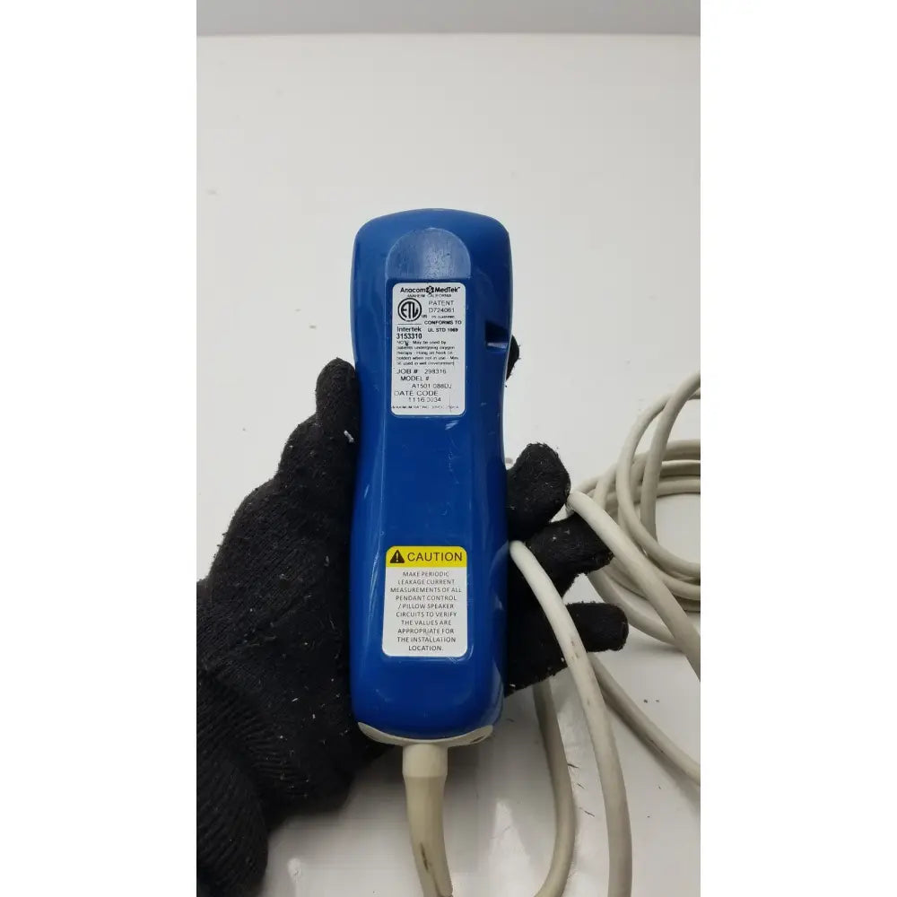Blue plastic anacom medtek medtek hd supply a1501-088dj pillow speaker remote with white label and warning sticker visible