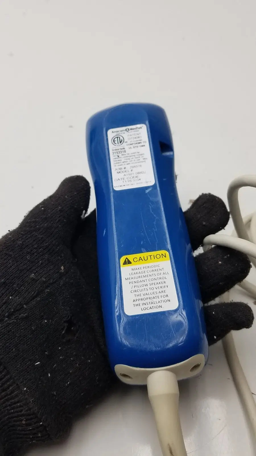 Blue plastic handheld electrical tester with white cable and warning labels for anacom medtek a1501-088dj pillow speaker remote