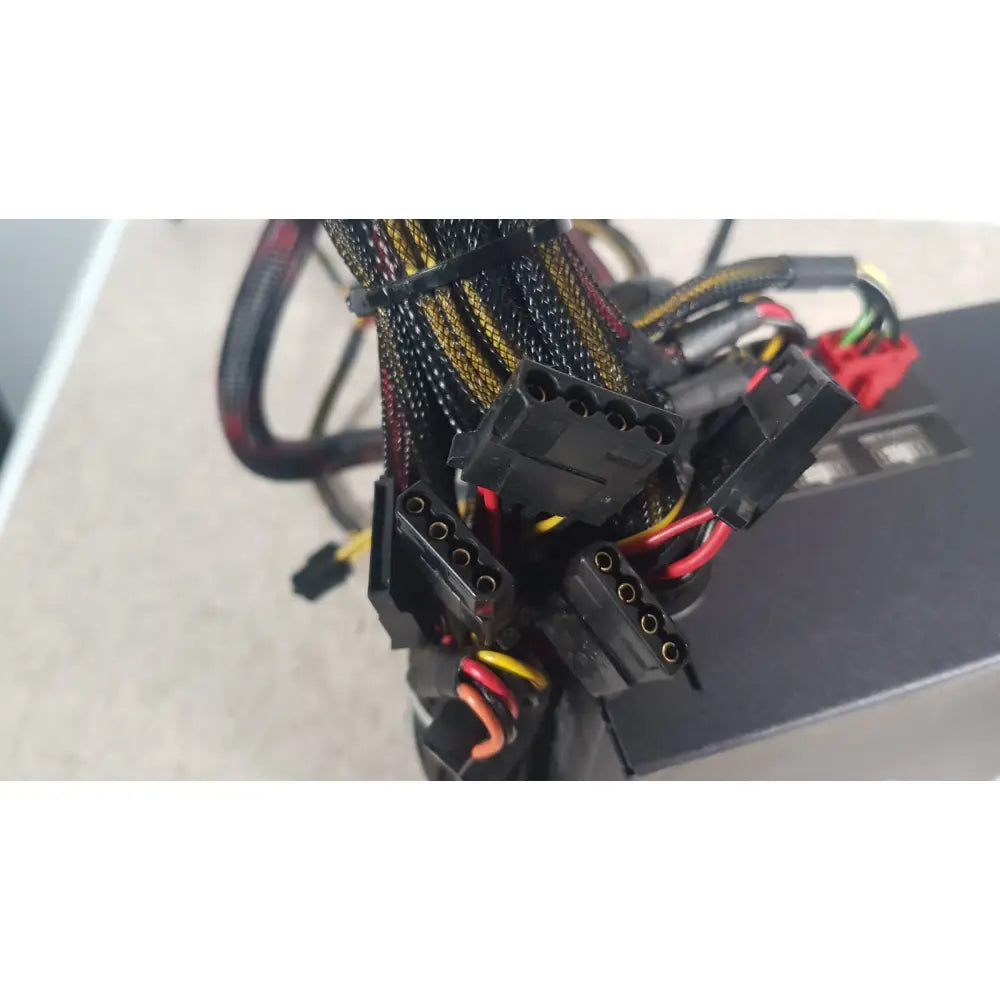 Black power supply cables with yellow and red wiring bundled by zip ties on the antec truepower 550w black unit