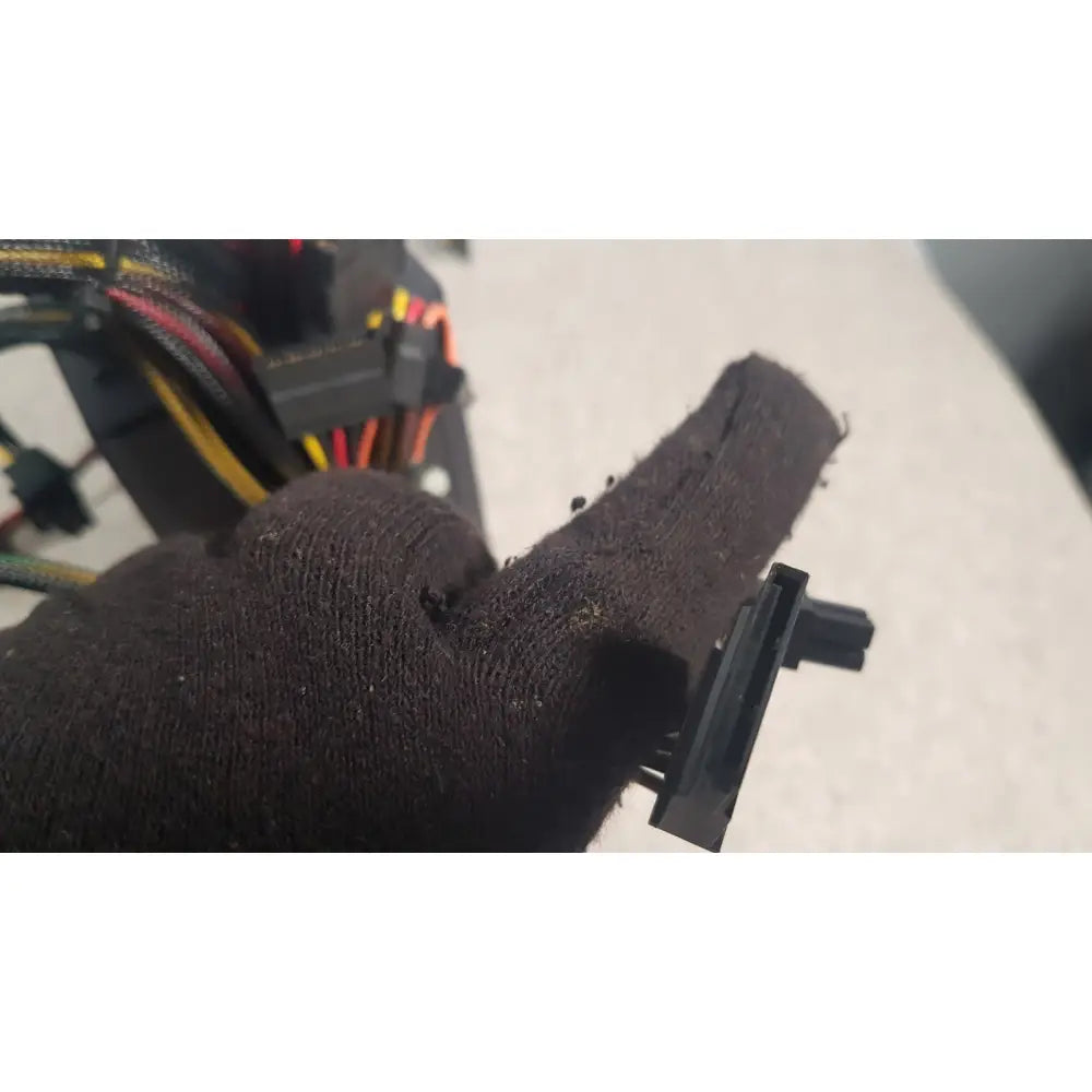 Black textured fabric glove holding black plastic connector of antec truepower 550w black switching power supply