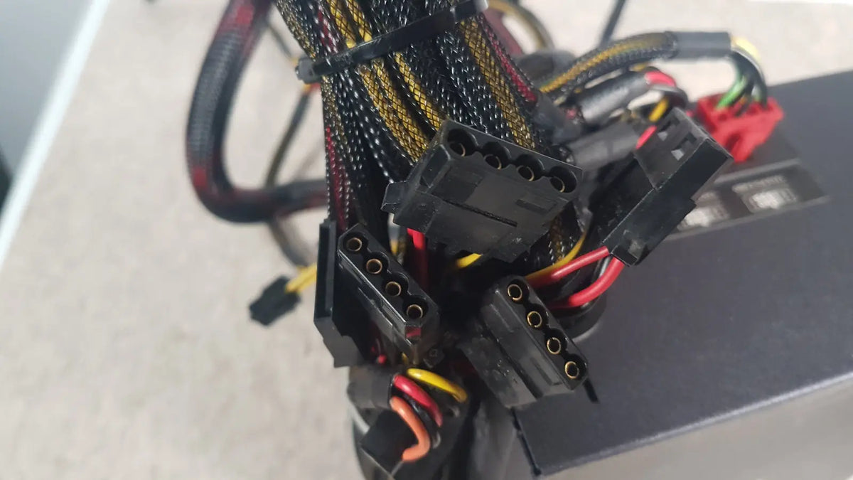 Black power supply cables with yellow and red wiring bundled by zip ties on the antec truepower 550w black unit