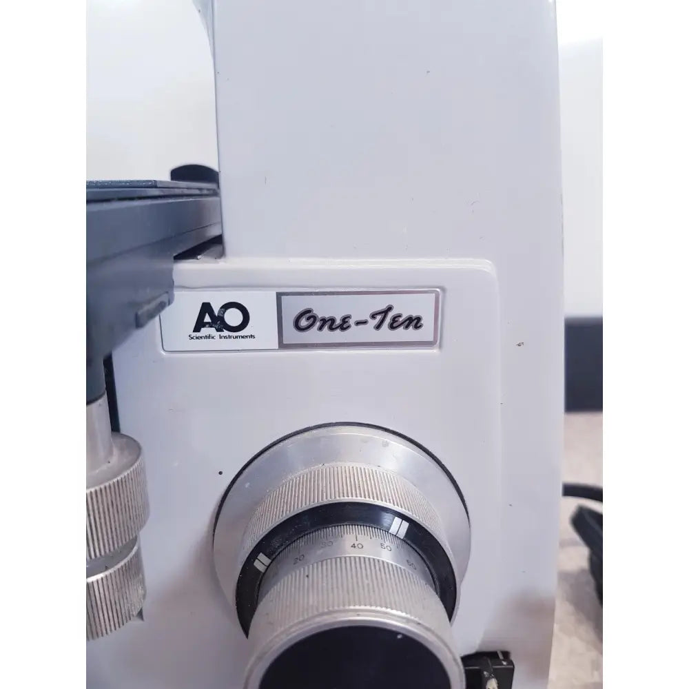 White AO scientific instruments one-ten microscope with silver metallic lens ring and engraved focus scale illuminator model