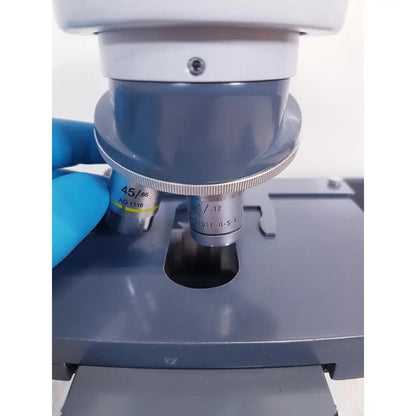 Gray and silver microscope objective lens with engraved markings from ao scientific instruments one-ten illuminator model 1130a