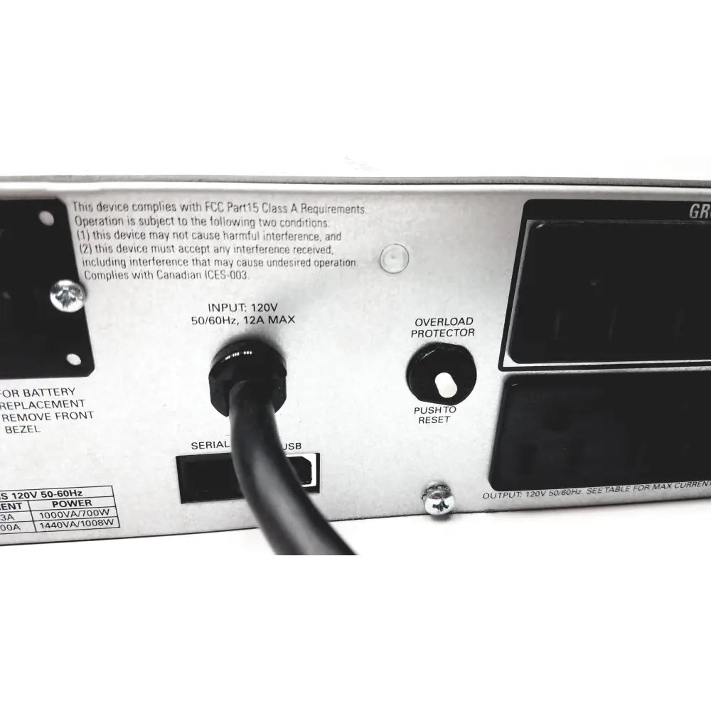 Silver metallic power supply unit with black ports and circular overload switch showing back view of schneider electric smart-ups smt1000rm2u