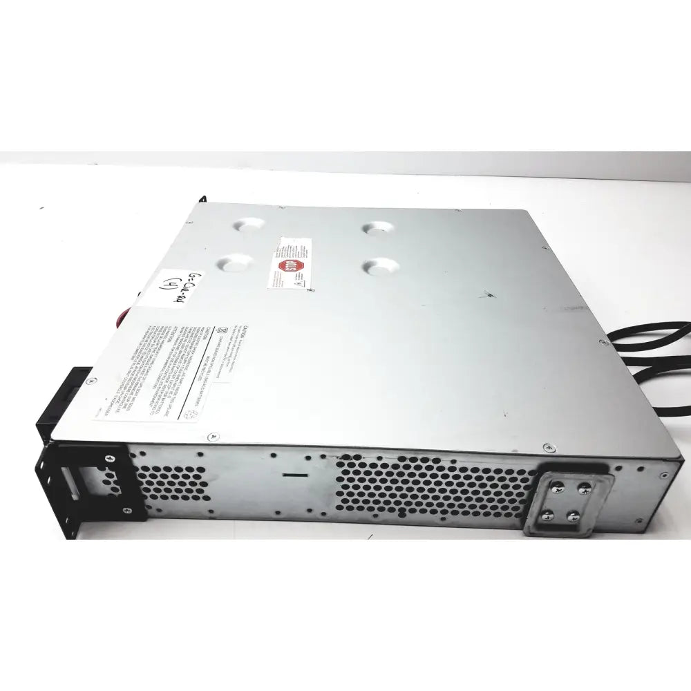 Silver metal server rack with black perforated panels and red sticker on top of schneider electric smart-ups smt1000rm2u
