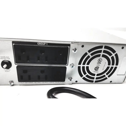 Back side of silver metal server rack with black plastic power outlets and fan vent in schneider electric smart-ups smt1000rm2u