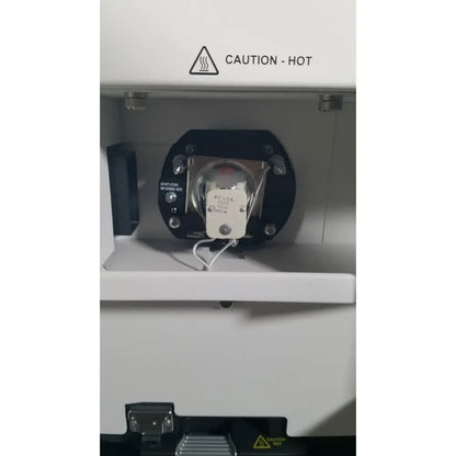 White industrial laser cutter with black circular component and metallic parts in applied biosystems quantstudio dx instrument