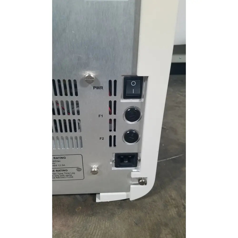 White and silver industrial power supply unit with black toggle switch on the back of applied biosystems quantstudio dx