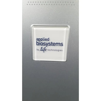 A sleek silver-framed white logo plaque displaying applied biosystems by life technologies on applied biosystems quantstudio dx instrument