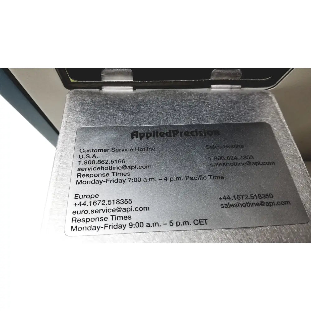 Silver metallic plaque with engraved black text displaying applied precision introduces arrayworxe biochip reader customer service hotline