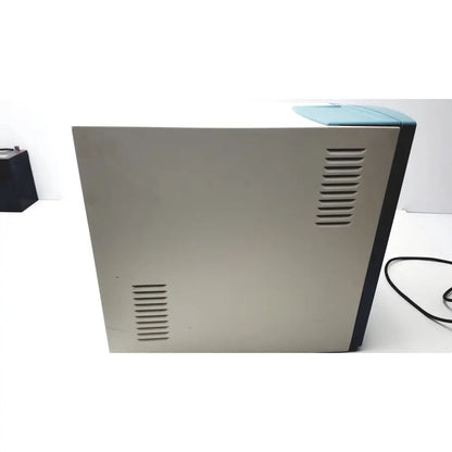 Beige and teal desktop printer with vertical ventilation slits on sides showing back view applied precision introduces arrayworxe biochip reader