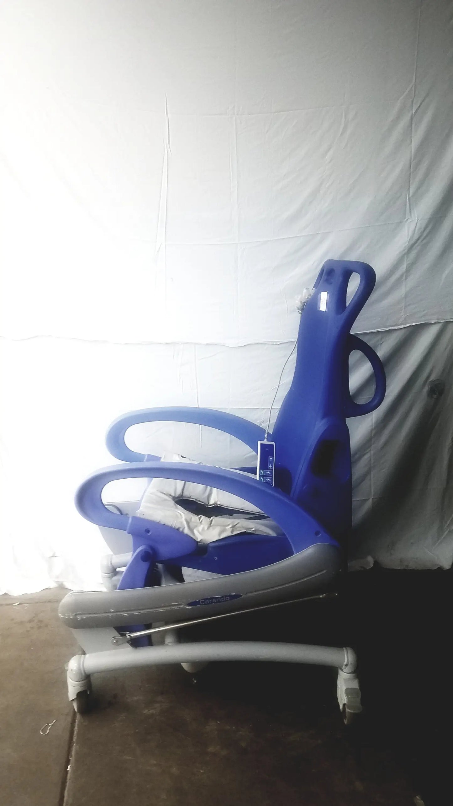 Blue and gray adjustable pediatric Arjo Carendo multipurpose hygiene chair with wheels for versatile care use