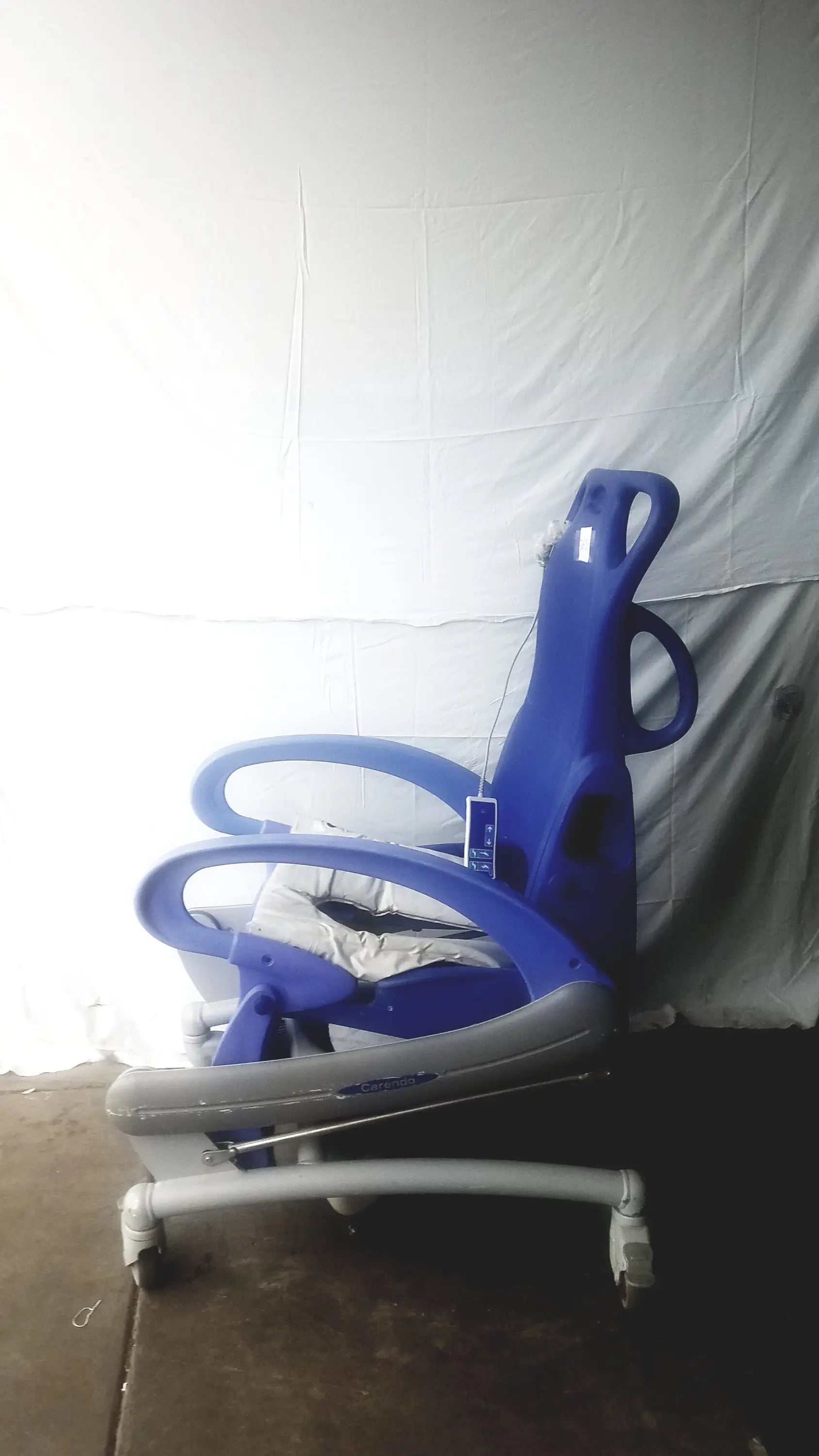 Blue and gray adjustable pediatric Arjo Carendo multipurpose hygiene chair with wheels for versatile care use