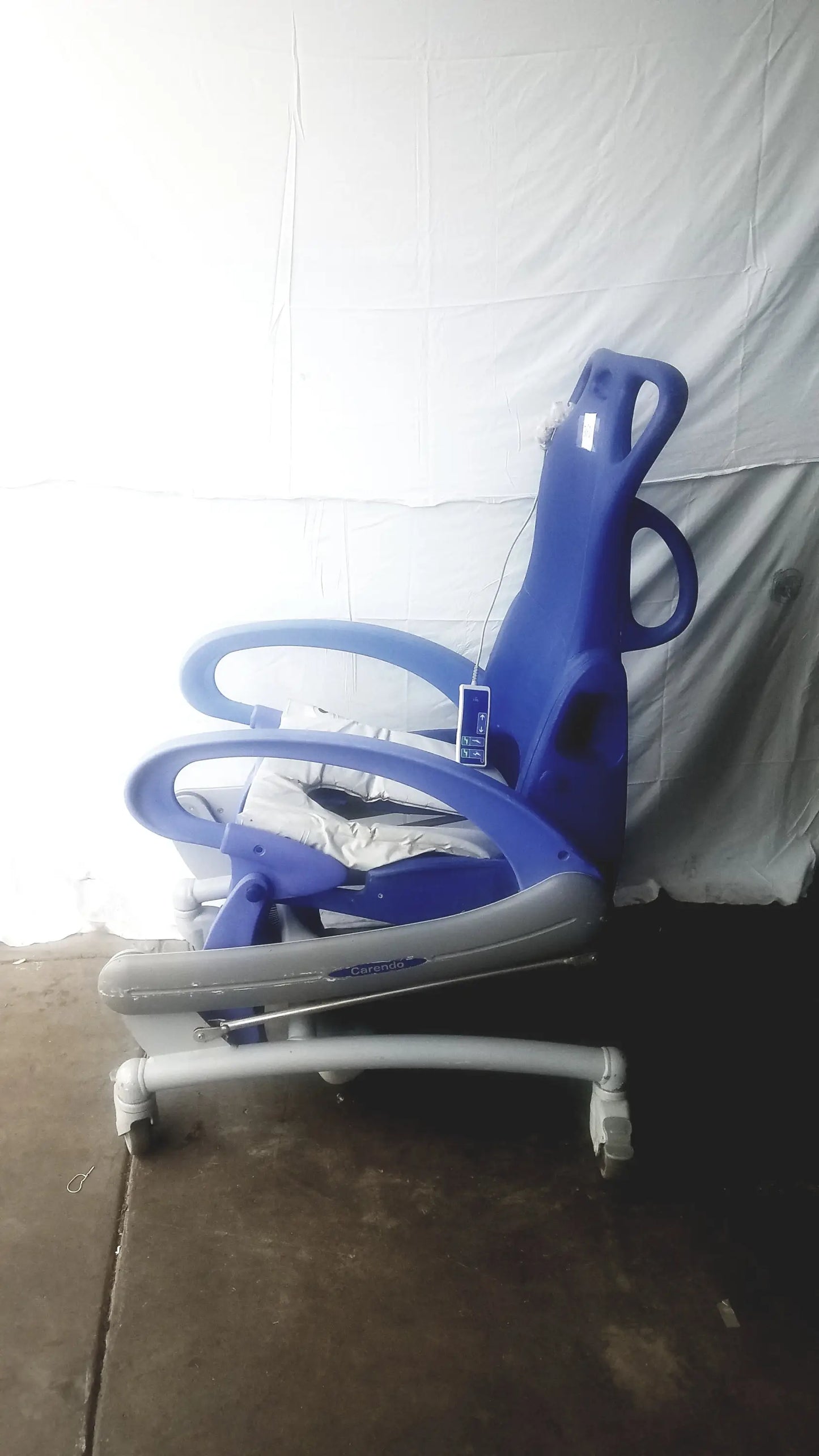 Blue and gray adjustable pediatric multipurpose hygiene chair with wheels by arjo carendo for versatile care