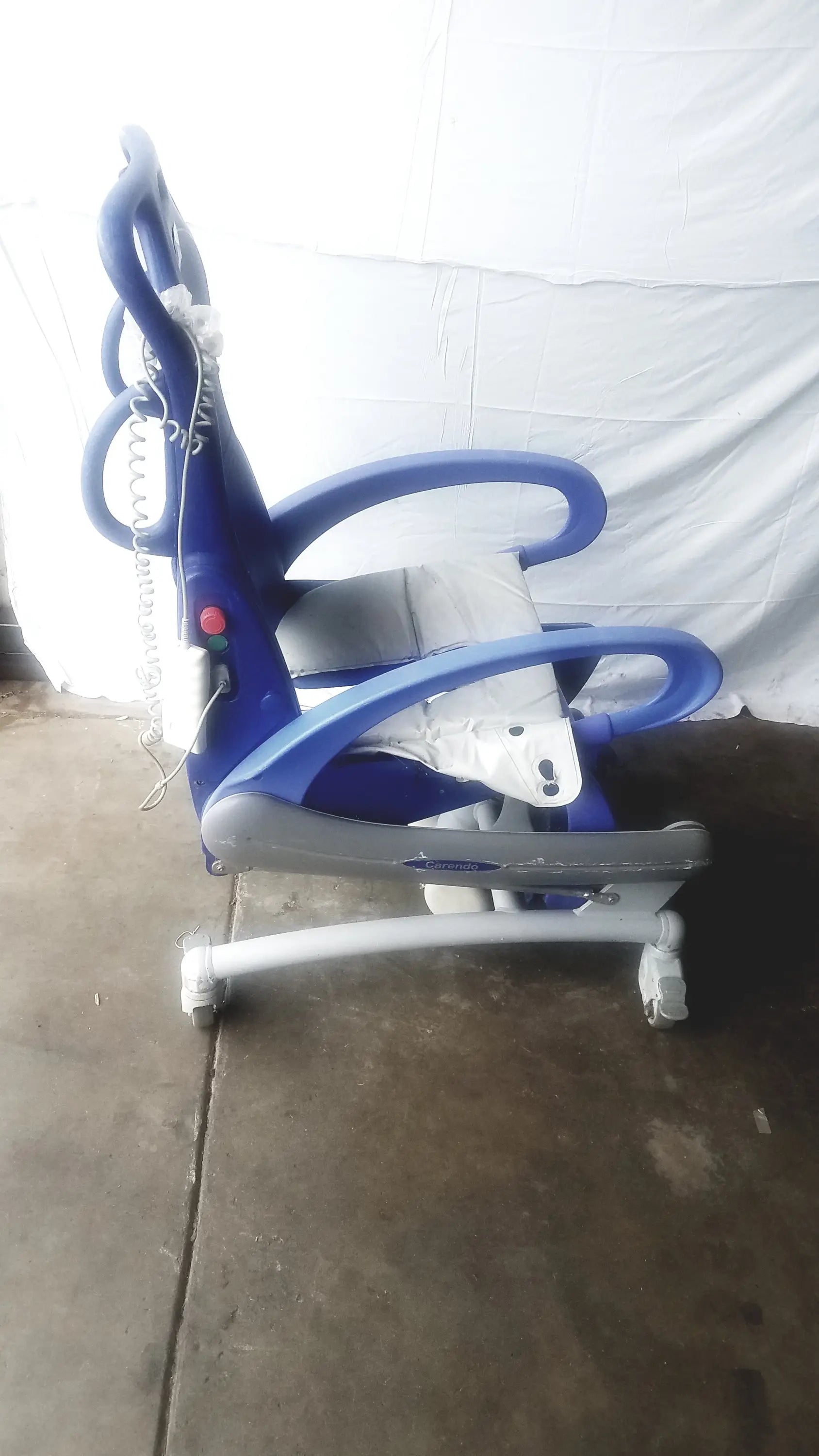 Arjo carendo multipurpose hygiene chair in blue and gray with curved armrests padded seat and wheels for mobility