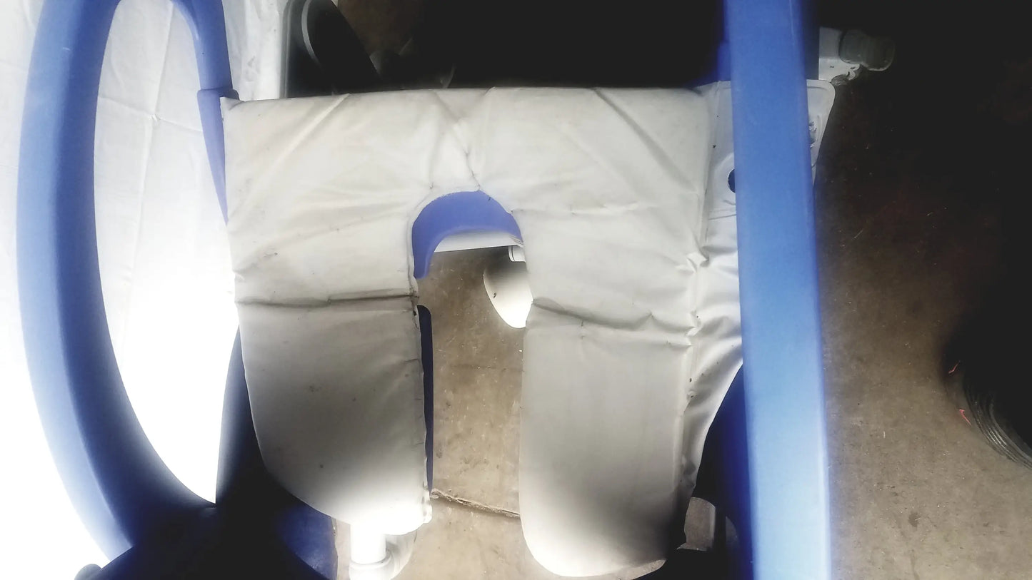 Blue plastic multipurpose hygiene chair with white padded seat and blue handlebars by Arjo Carendo